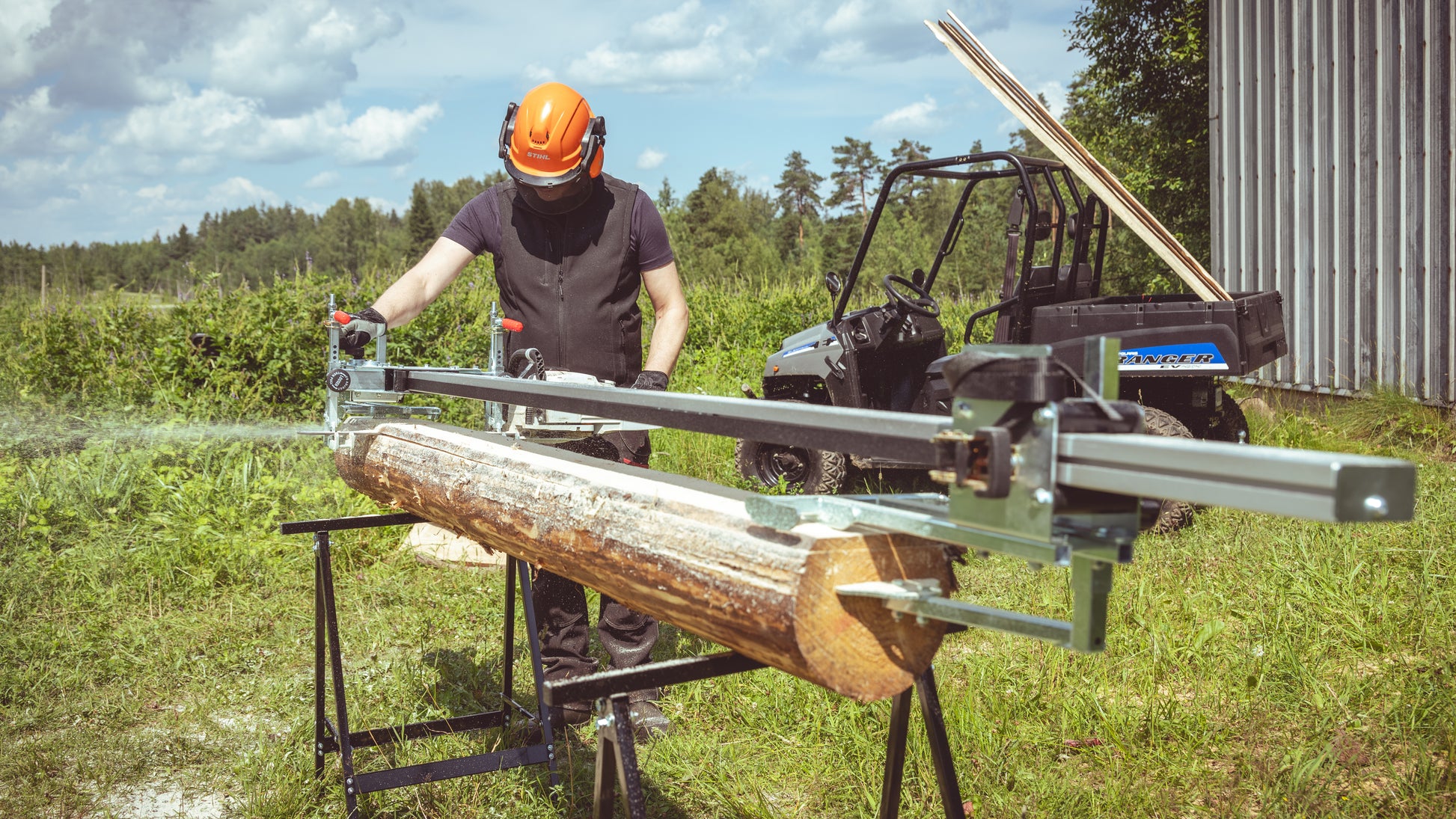 Person using ClampMill chainsaw mill to cut logs outdoors